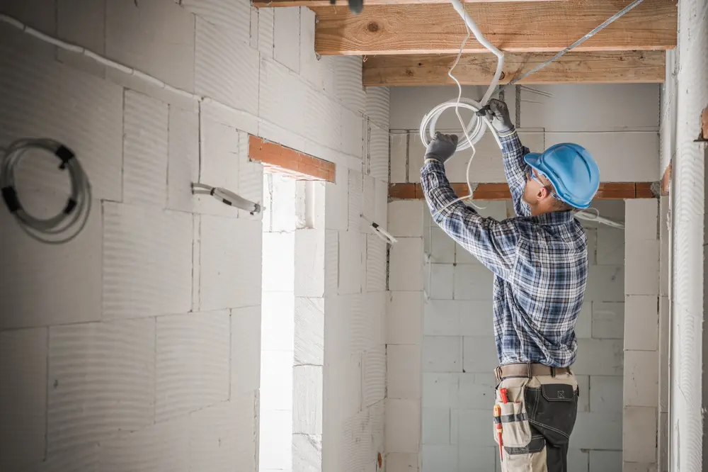 Electrician inspecting old cloth-insulated wiring in the attic of an older home